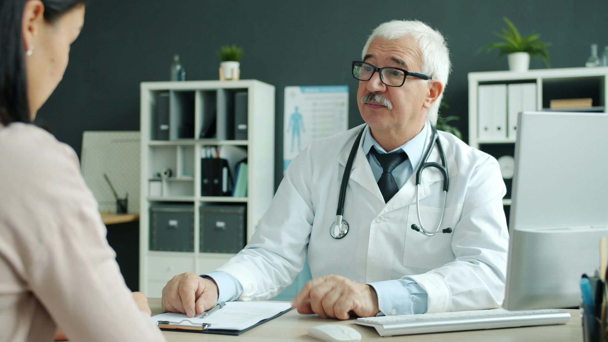 Médico atendiendo a una paciente en su consulta