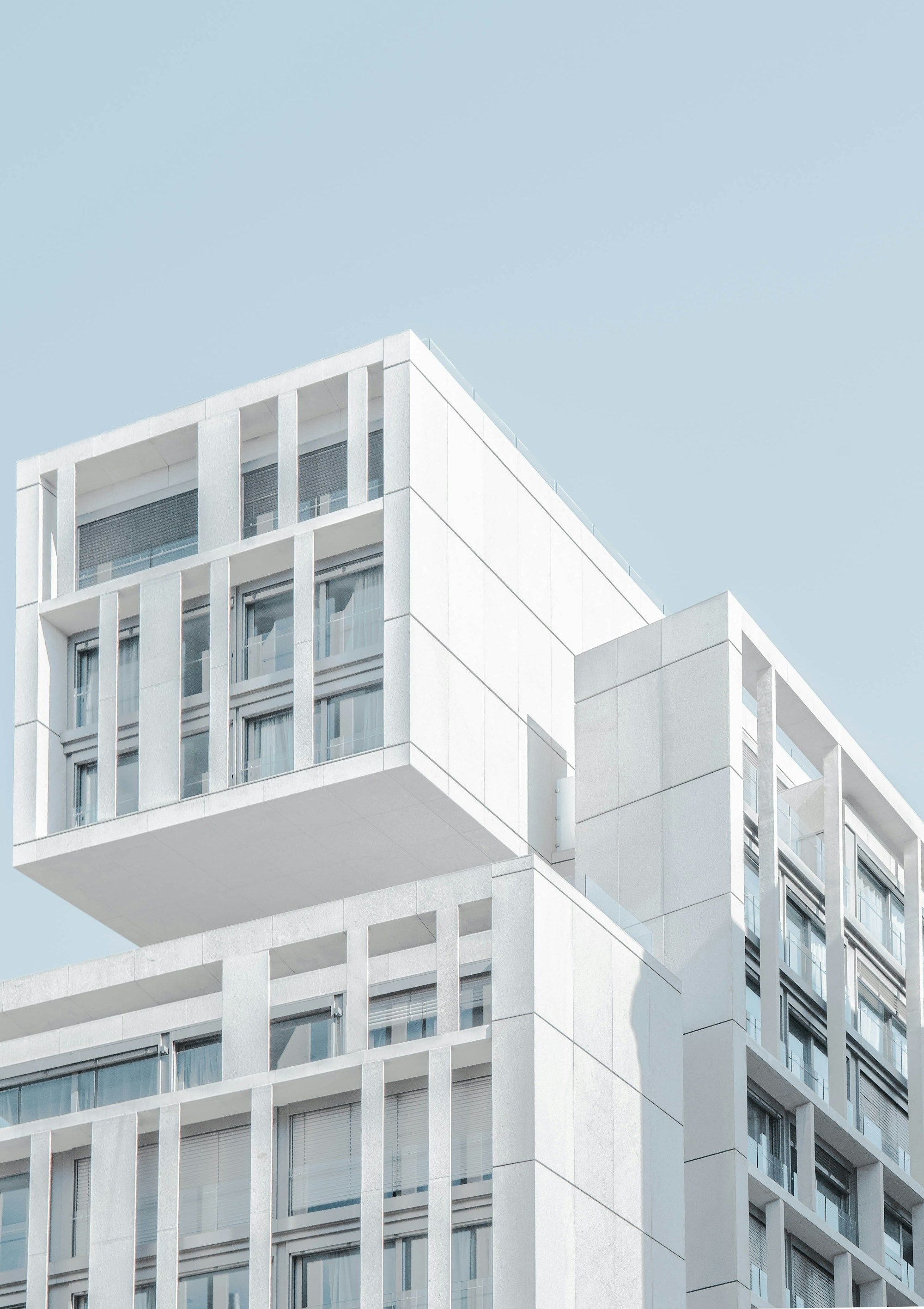 Edificio de viviendas moderno de fachada blanca contra un cielo despejado
